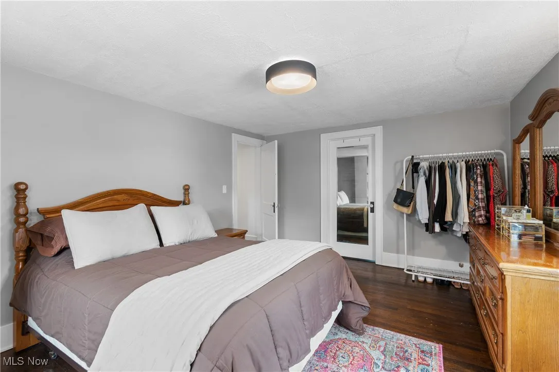 Bedroom with dark wood-type flooring, a closet, and a textured ceiling