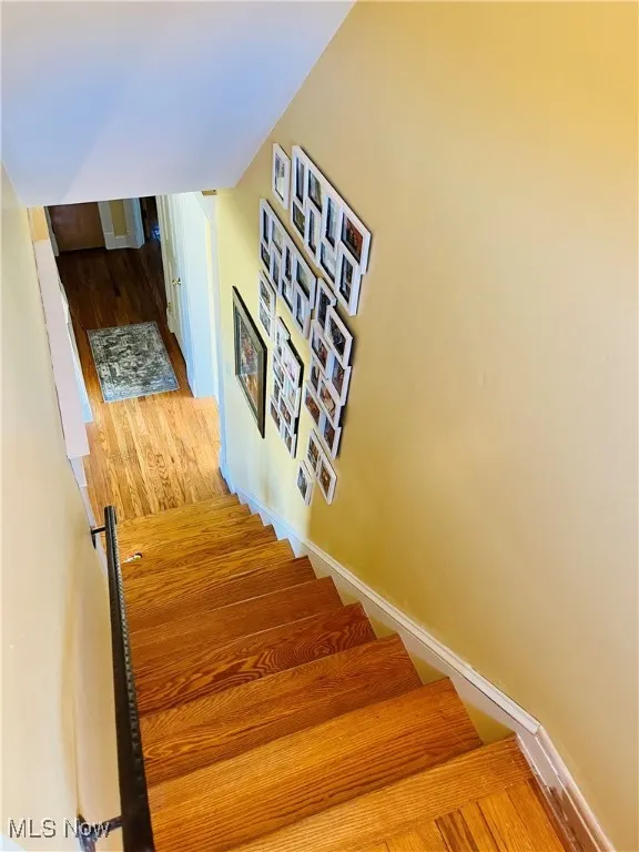 Stairway featuring baseboards and wood finished floors