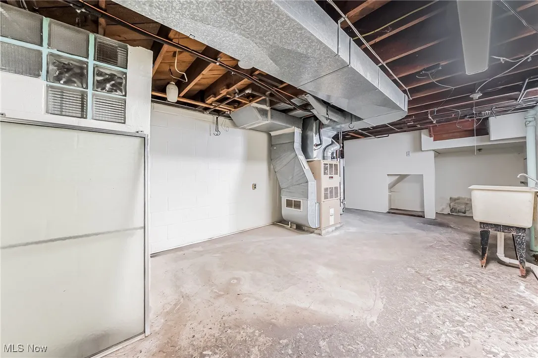 Basement featuring sink and heating unit