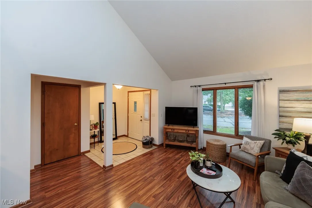 Living room with high vaulted ceiling and wood finished floors