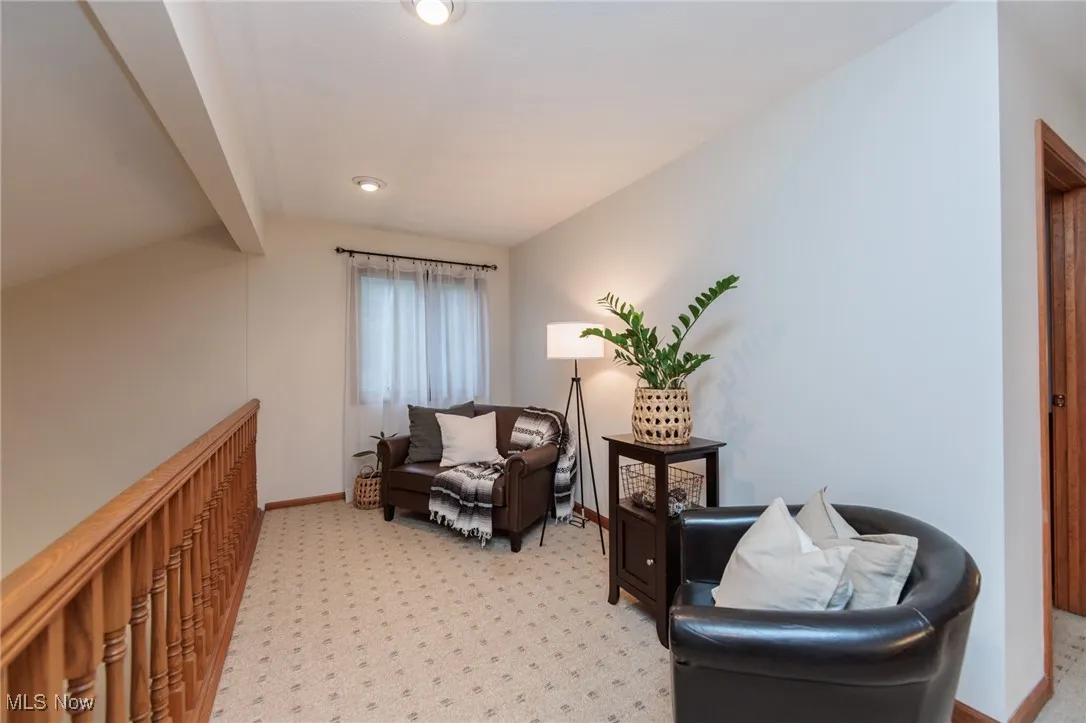 Living area with light carpet and baseboards