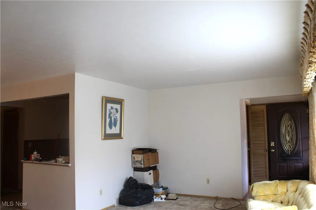 Carpeted living room featuring baseboards