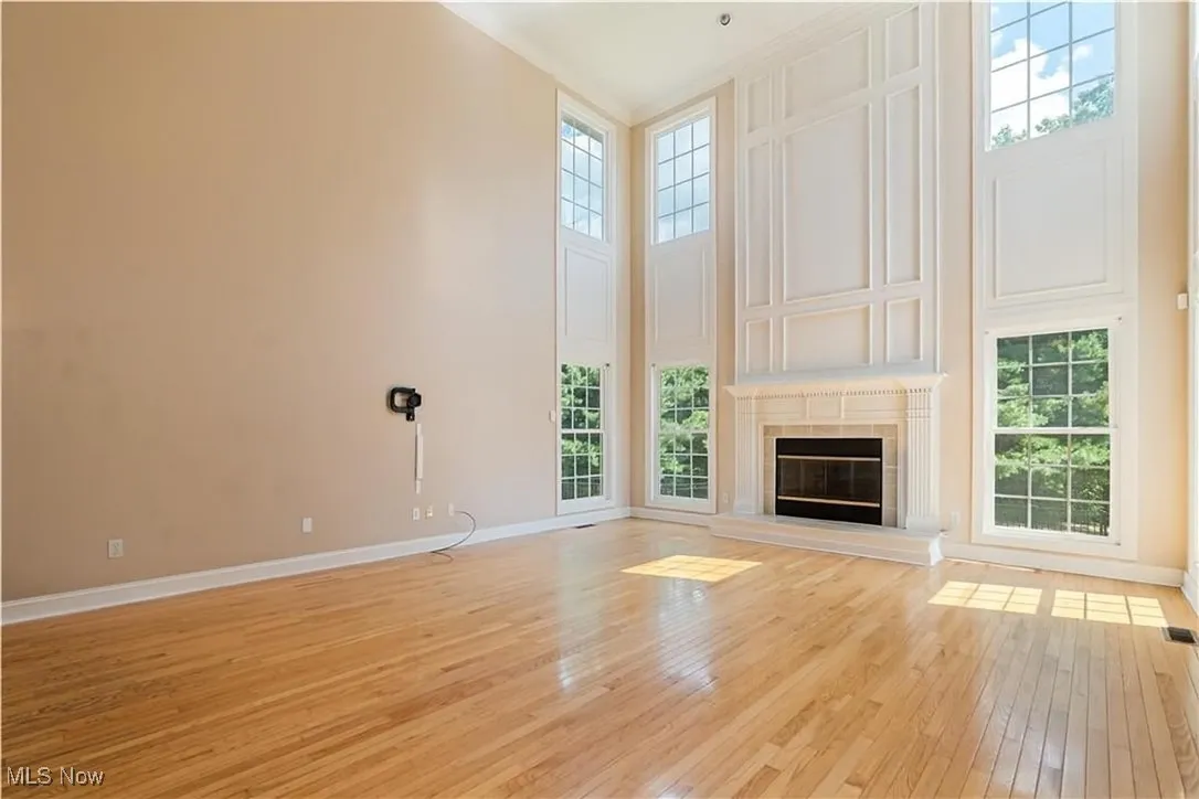The large great room with high ceilings and gas fireplace and hardwood flooring.   Please look at the large beautiful windows with natural light.