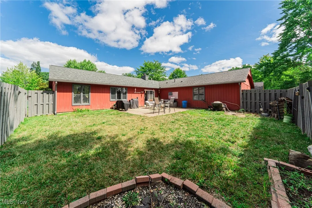 Rear view of property featuring a patio area, a fenced backyard, and roof with shingles