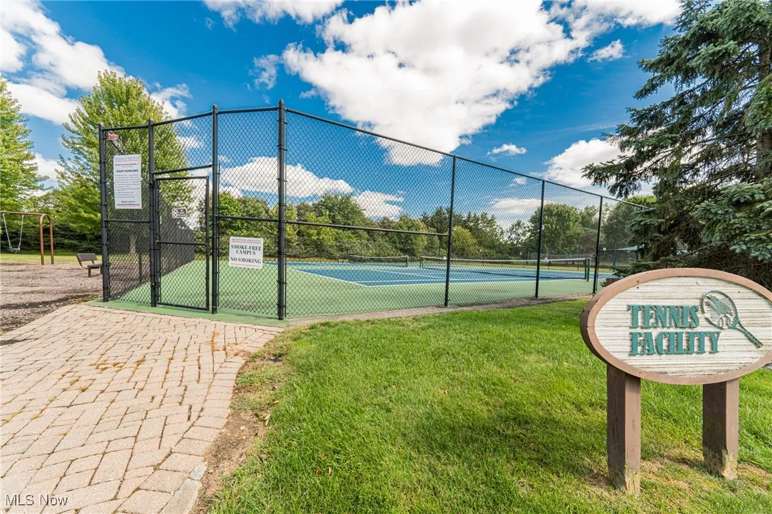 View of tennis court featuring a gate