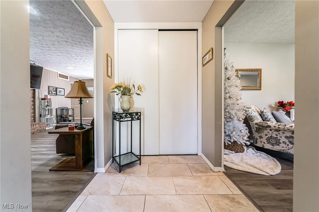 Entryway with a textured ceiling and light wood-style flooring