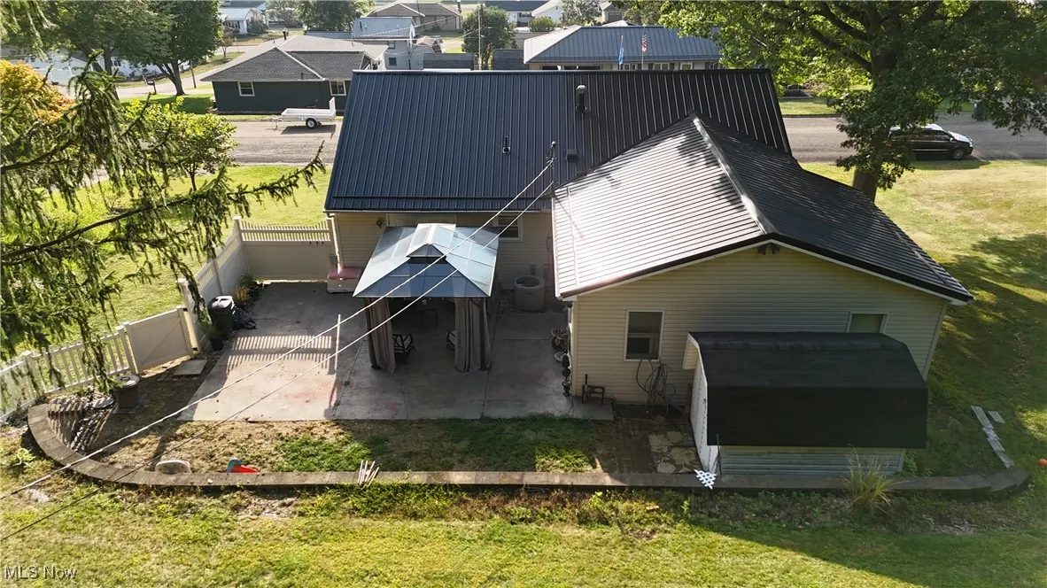 Back of property featuring a patio, a metal roof, and a fenced backyard