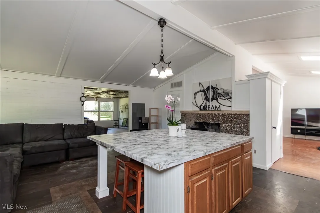 Kitchen with open floor plan, light countertops, a breakfast bar, and decorative light fixtures