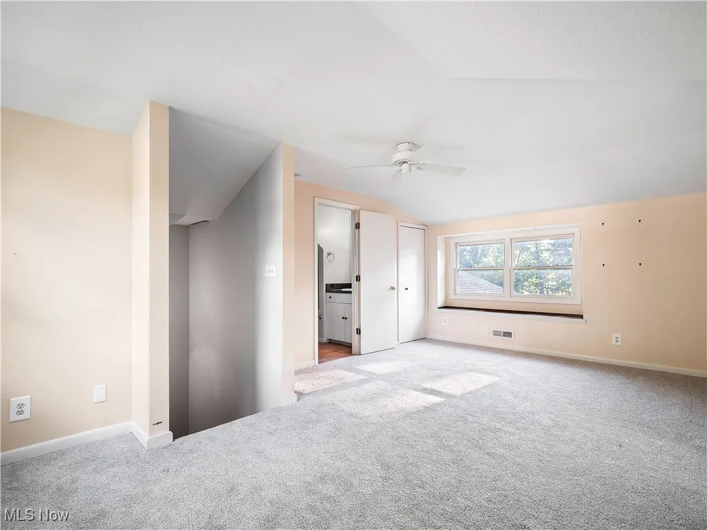 Bonus room with carpet floors, ceiling fan, and vaulted ceiling