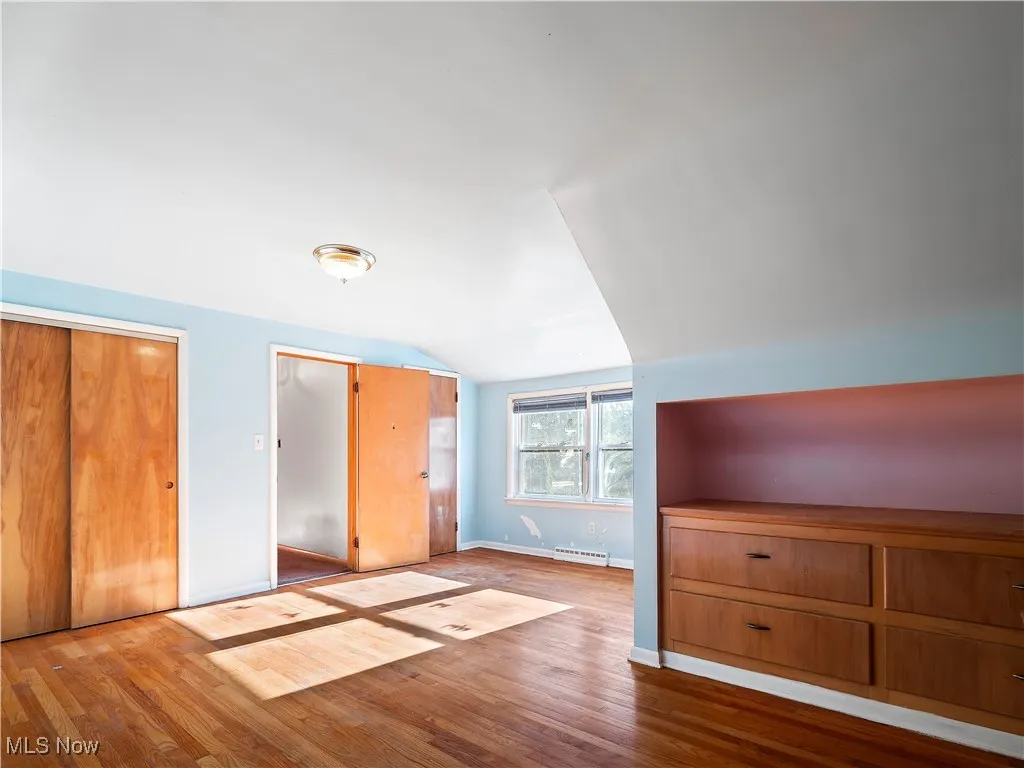 Bonus room featuring wood finished floors and vaulted ceiling