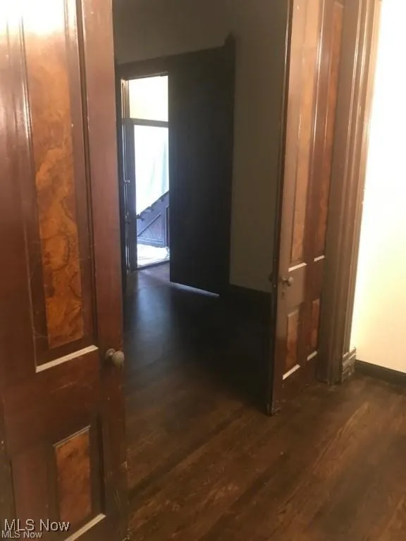 Hallway featuring dark wood-style floors
