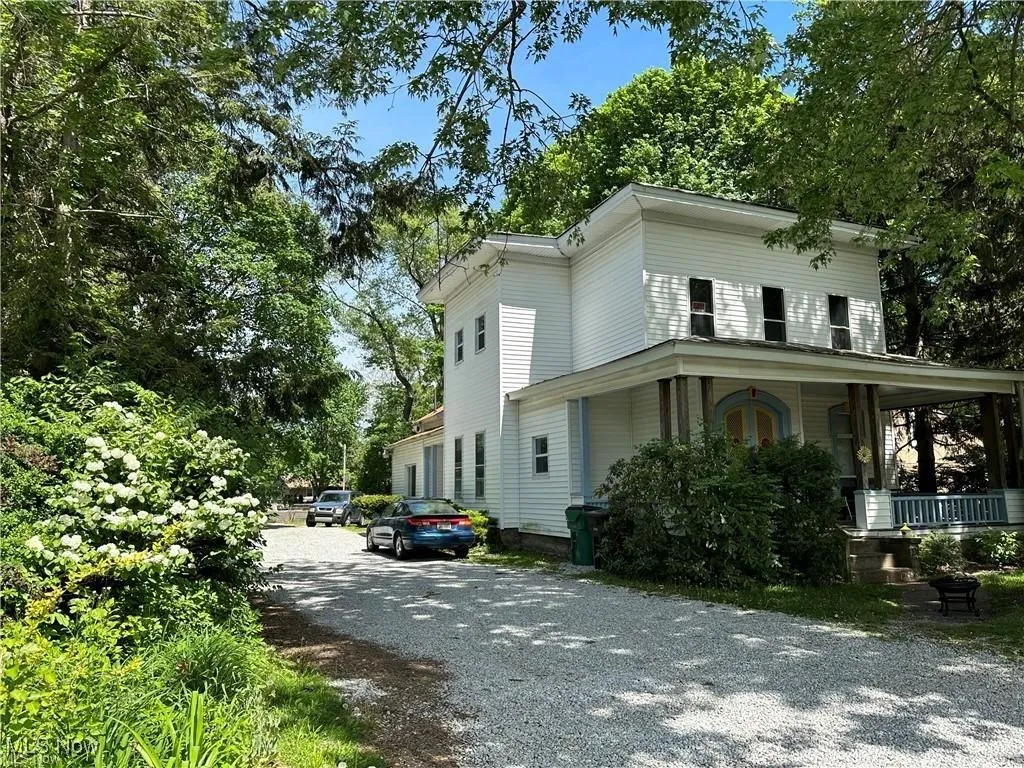 View of side of home with a porch and driveway