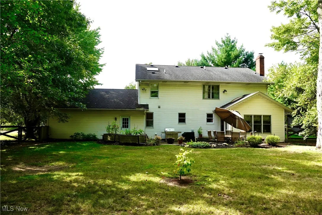 Rear view of house with a chimney and a patio