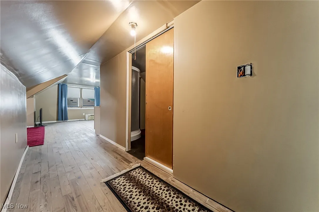 Hallway featuring hardwood / wood-style floors and lofted ceiling