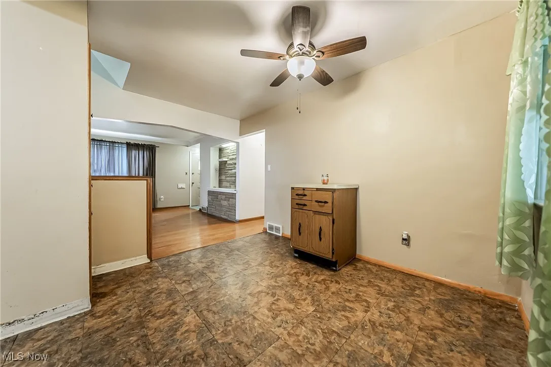 Spare room with a ceiling fan and dark stone finish flooring