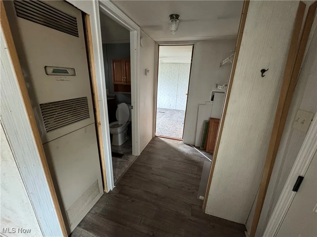 Hallway featuring a heating unit and dark wood-style floors