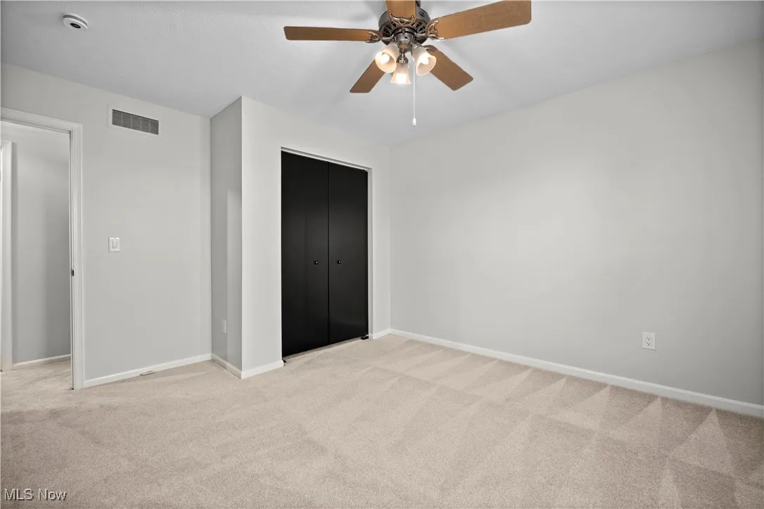 Unfurnished bedroom with carpet floors, a closet, and a ceiling fan