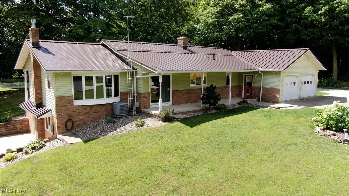 Parcel 1 Ranch-style home featuring brick siding, a chimney, covered porch, and a metal roof