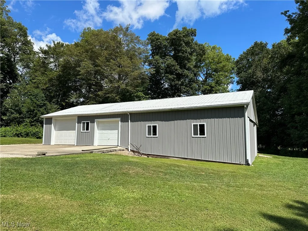 Parcel 1 View of front of property featuring an outbuilding, a front yard, and a metal roof