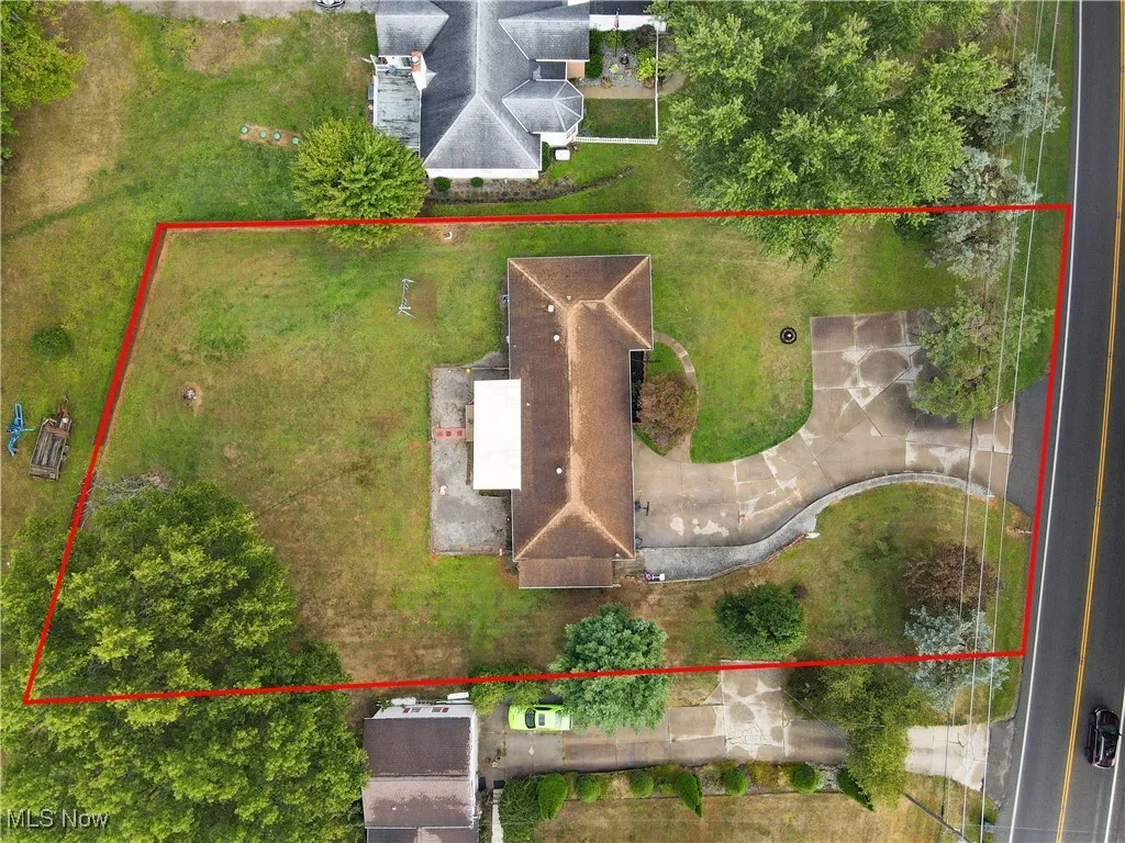 Aerial view of property and surrounding area with property parcel outlined