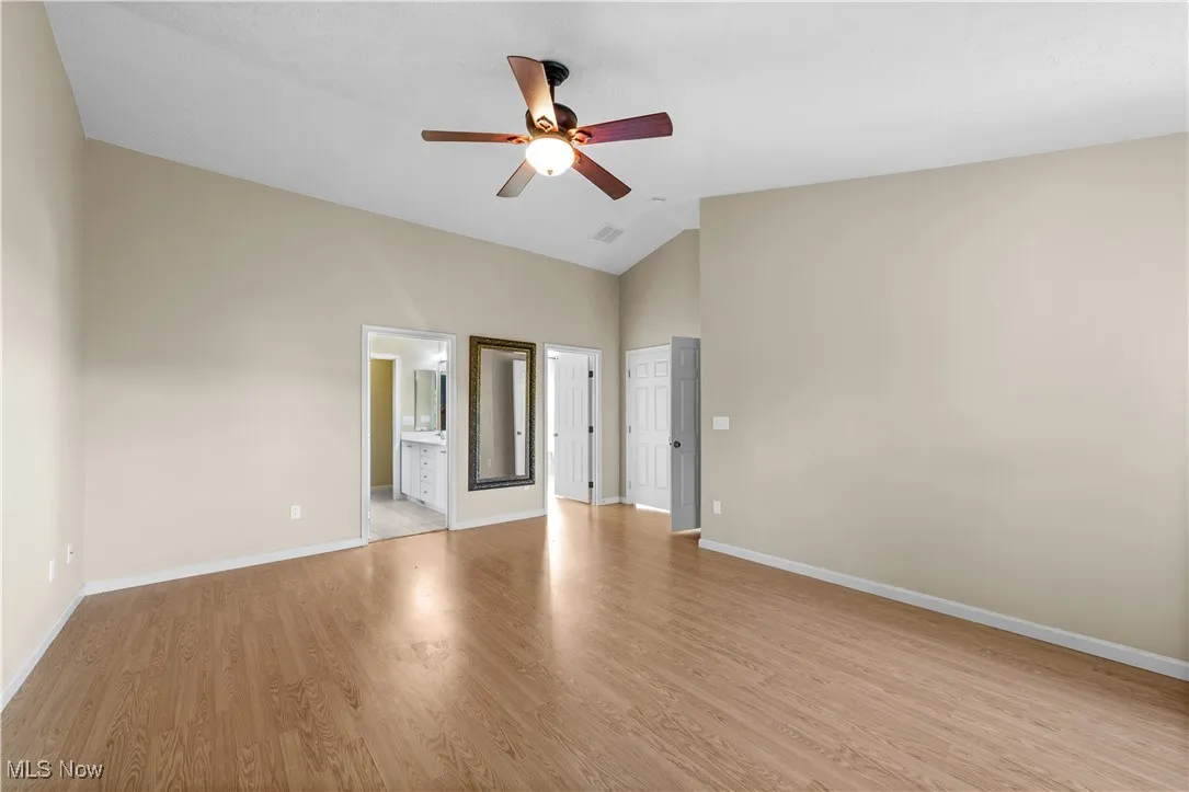 Primary bedroom with high ceilings and ceiling fan