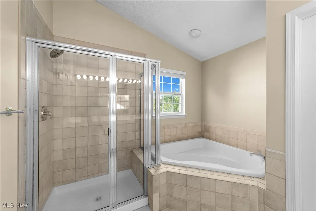 Primary bathroom with large tub and step in shower
