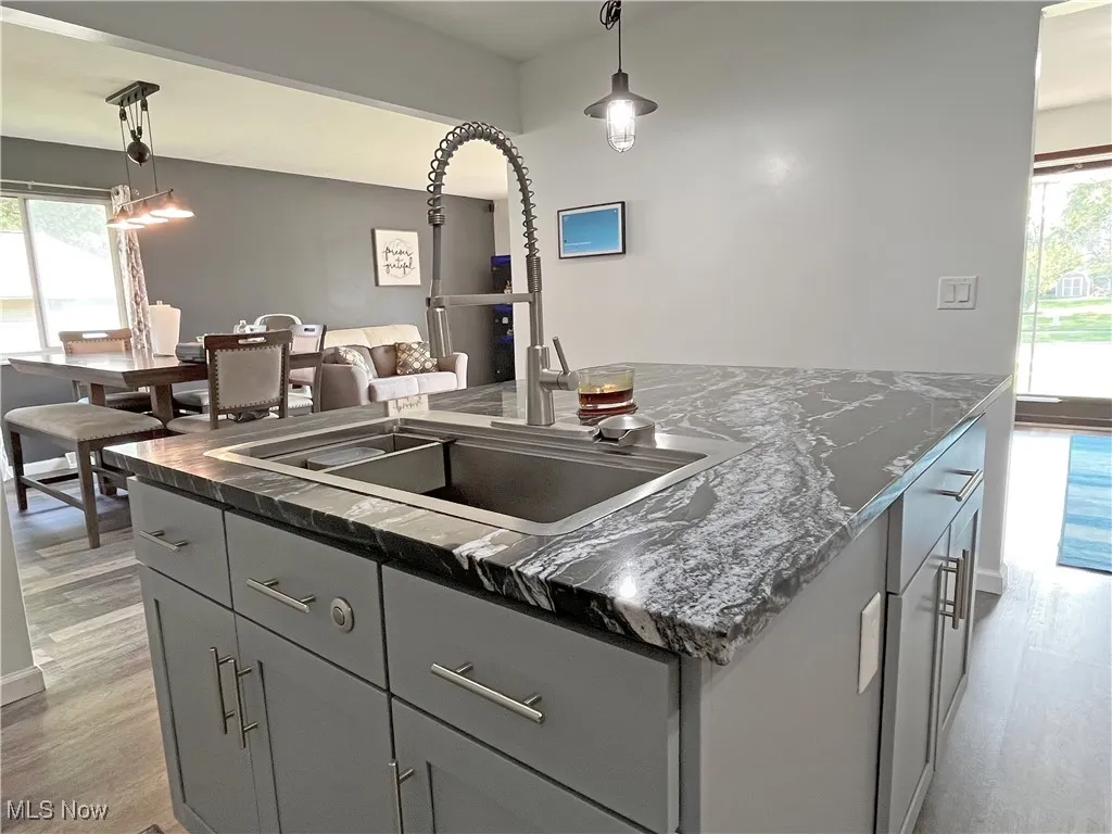 Kitchen with plenty of natural light, gray cabinets, a center island, and light wood-style flooring
