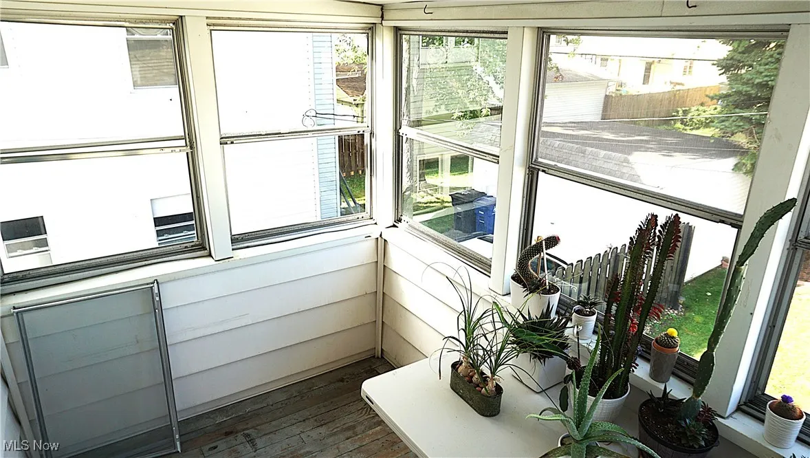 Sunroom / solarium featuring healthy amount of natural light and wood-type flooring