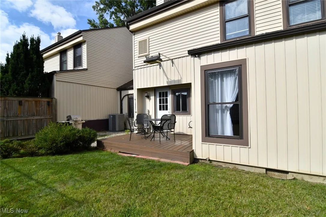 Back of house with a wooden deck and board and batten siding