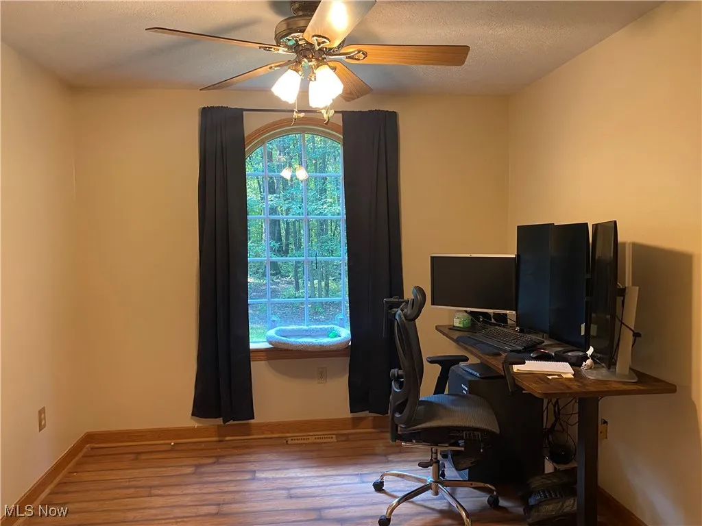 Office space featuring hardwood / wood-style flooring, a ceiling fan, and a textured ceiling