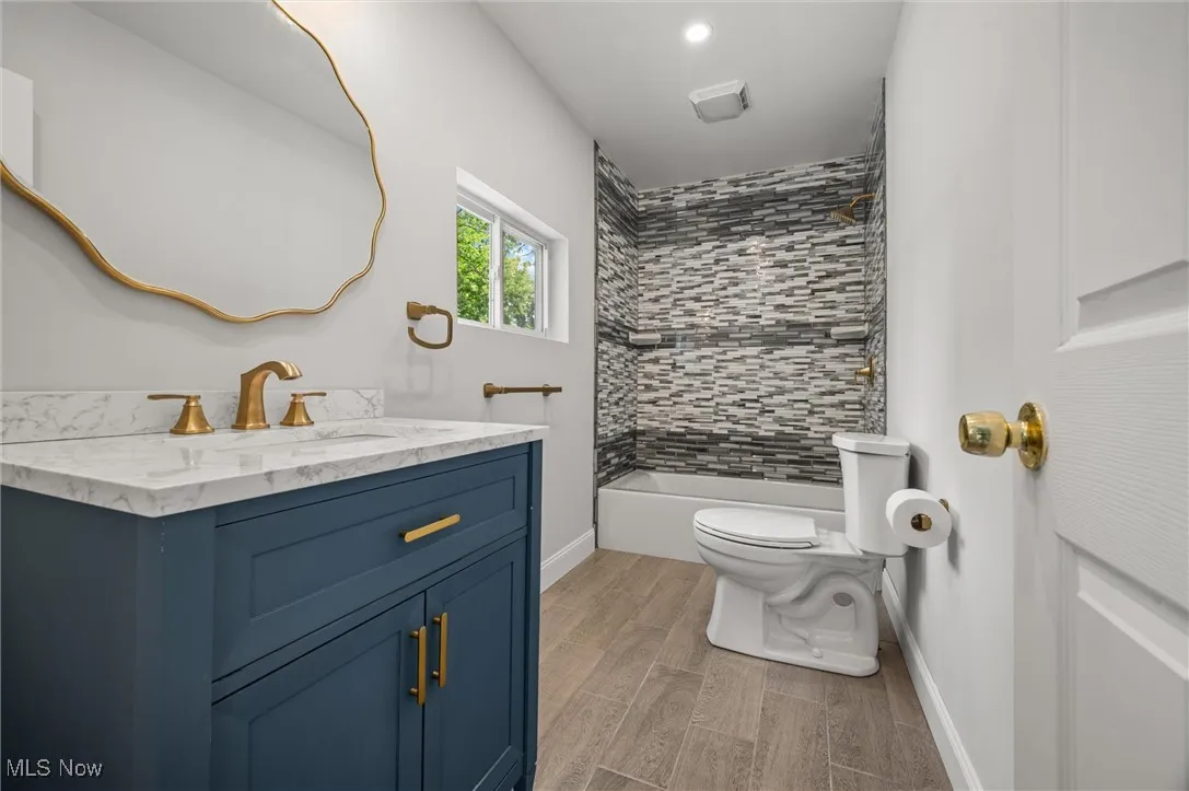 Bathroom with vanity,  shower combination, and wood tiled floors