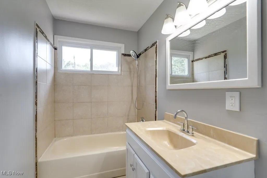 Bathroom featuring bathtub / shower combination and vanity