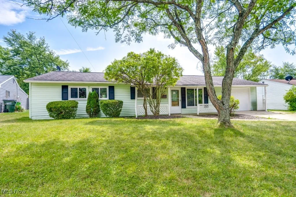 Ranch-style home featuring a garage, a front yard, and driveway