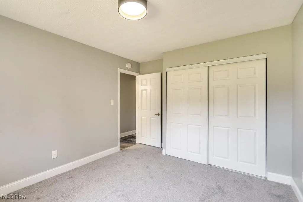 Unfurnished bedroom featuring carpet flooring and a closet