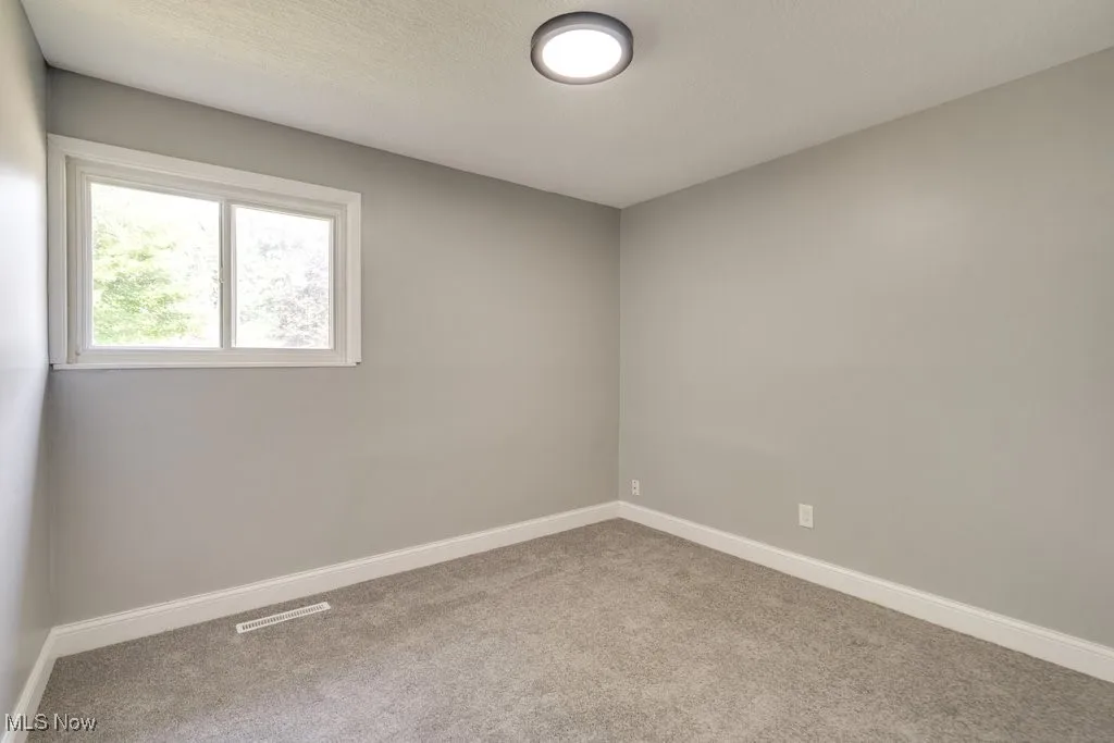 Carpeted empty room with baseboards and a textured ceiling