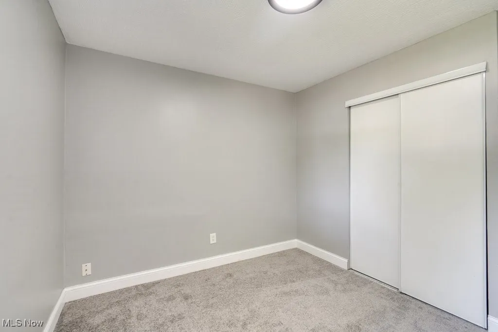 Unfurnished bedroom featuring carpet floors and a closet