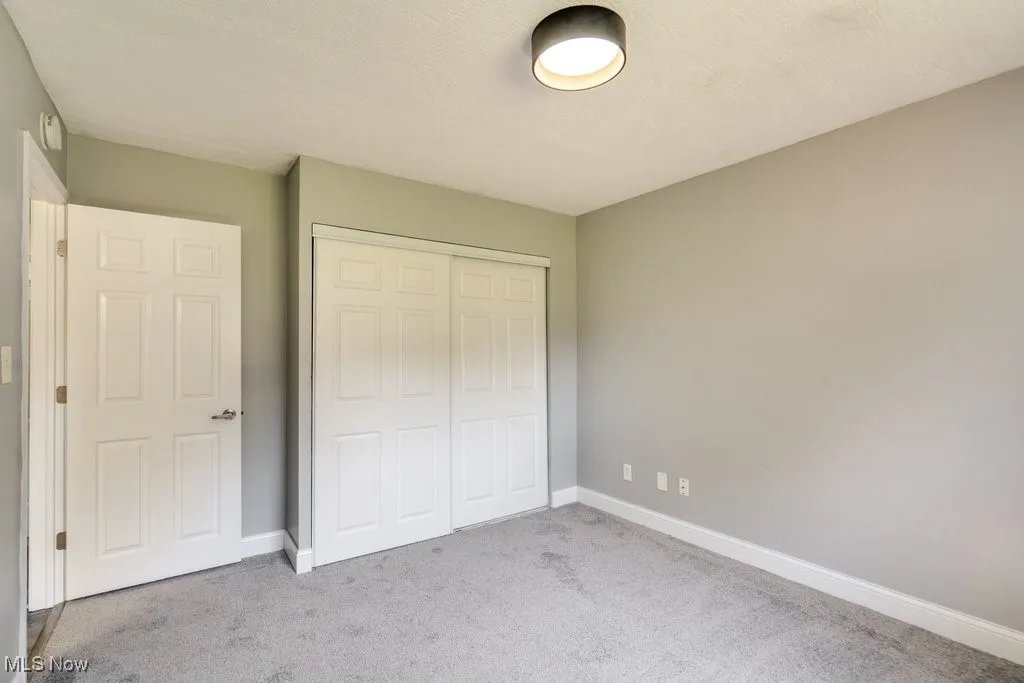 Unfurnished bedroom featuring carpet, a closet, and a textured ceiling