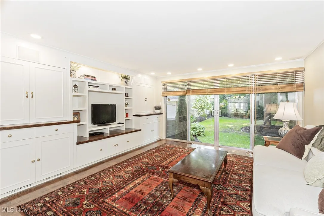 Family room with custom built-ins and a gorgeous view of the back yard through the rear wall of windows and slider.