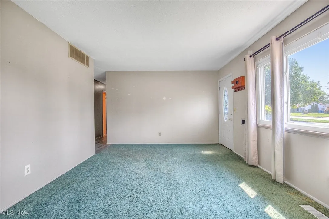 Carpeted empty room with baseboards