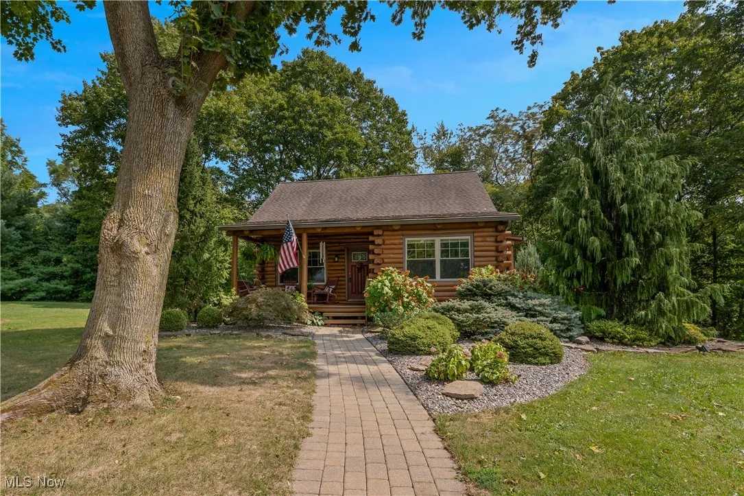 Cabin featuring log exterior, a front lawn, and a porch