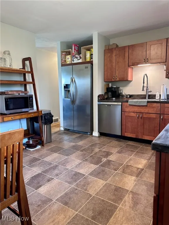 Kitchen featuring stainless steel appliances and brown cabinetry