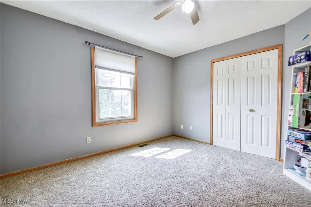 Unfurnished bedroom featuring a closet, carpet floors, and ceiling fan