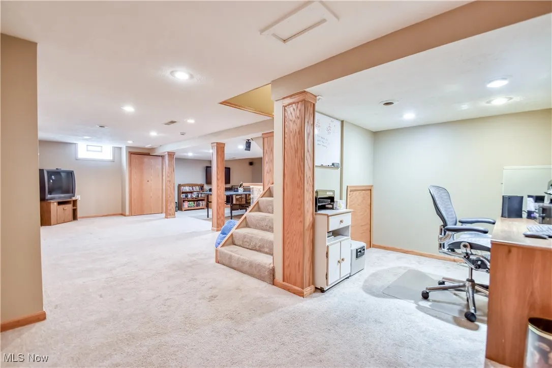 Home office with light carpet and recessed lighting