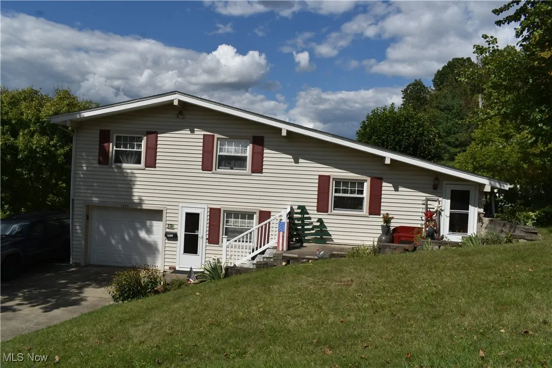 View of front of property featuring a front lawn, a garage, and driveway