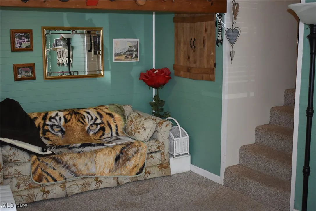 Carpeted living room featuring stairs