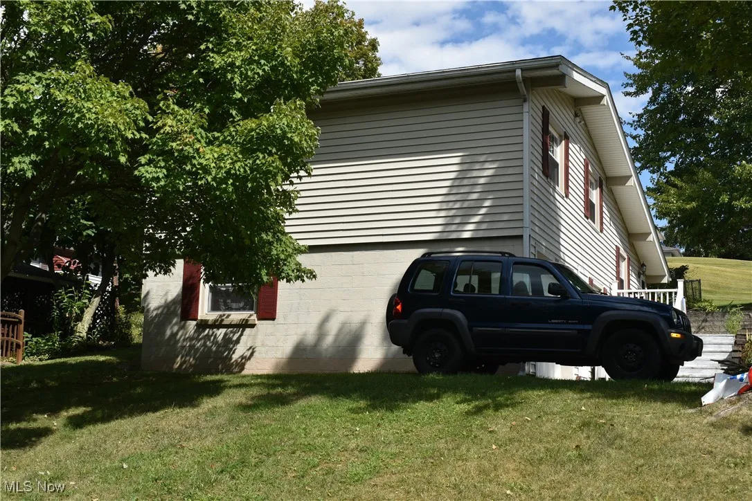 View of side of property with a lawn
