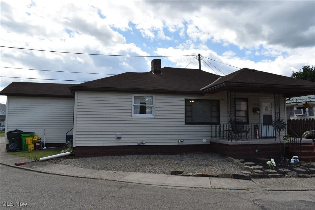 View of front of house featuring covered porch and a chimney