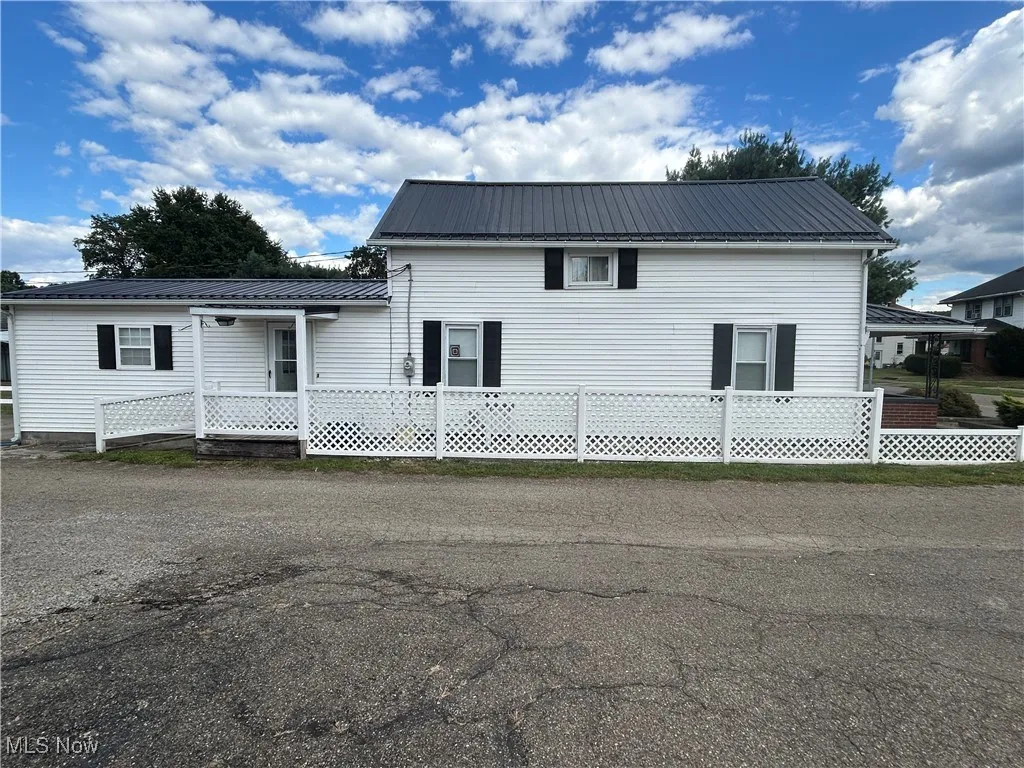 View of front of property featuring a metal roof and a wooden deck