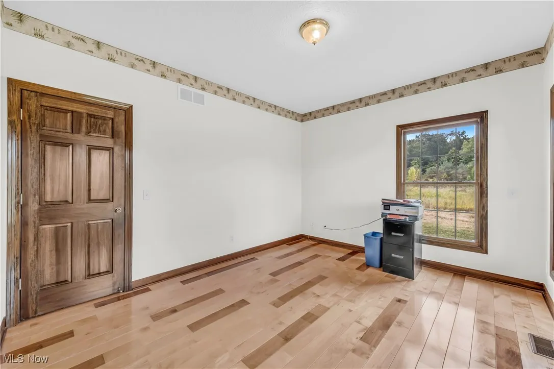 4th bedroom / office with light wood finished floors and baseboards