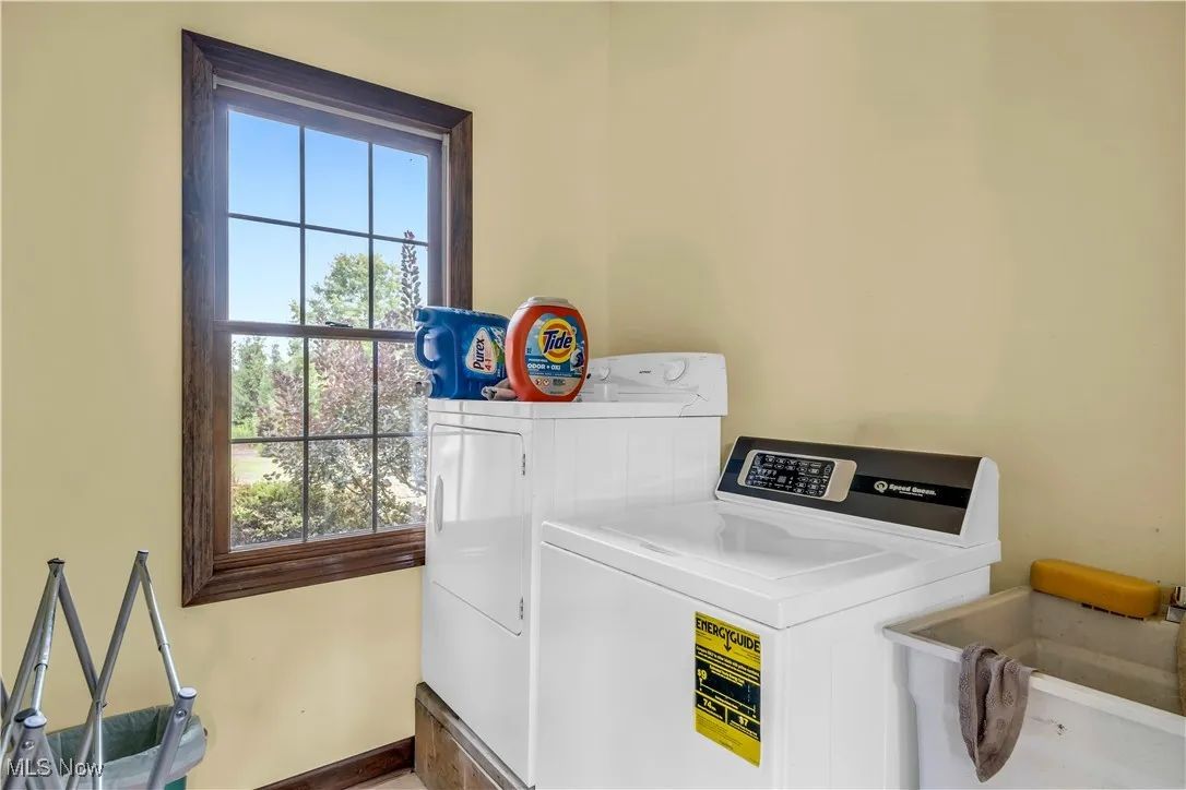 Laundry area featuring separate washer and dryer and baseboards